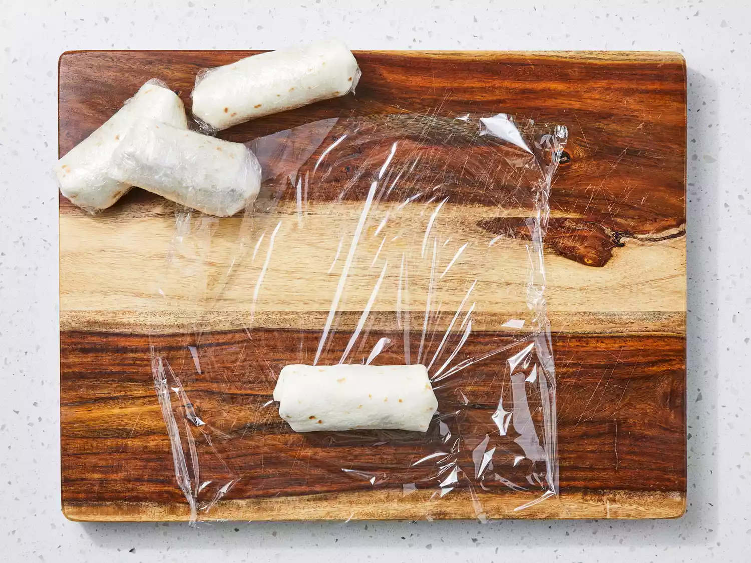 wrap folded burritos in plastic wrap.