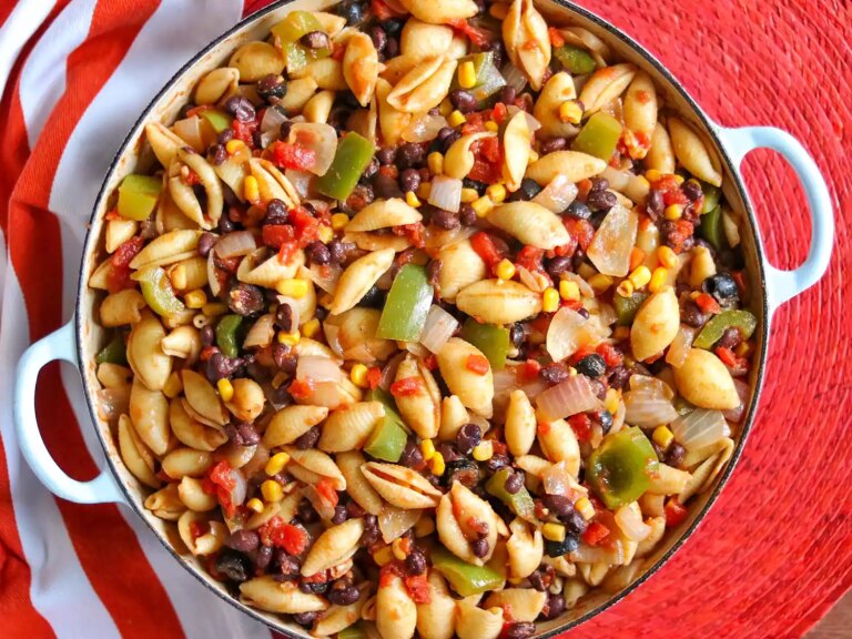 Colorful mexican pasta with corn and bell peppers in round cast iron pan