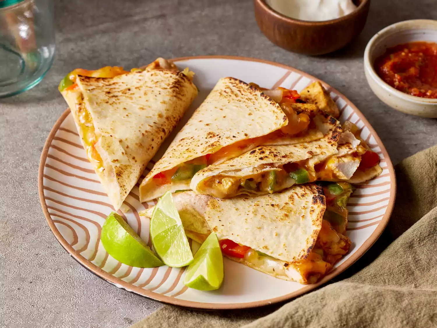 chicken quesadilla cut into fours, and served with salsa and sour cream.