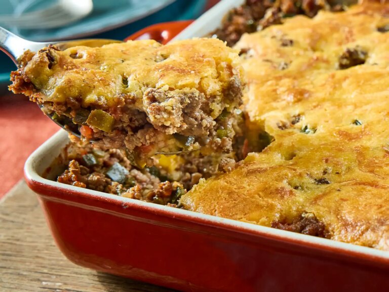 A hot tamale pie being served from a baking dish