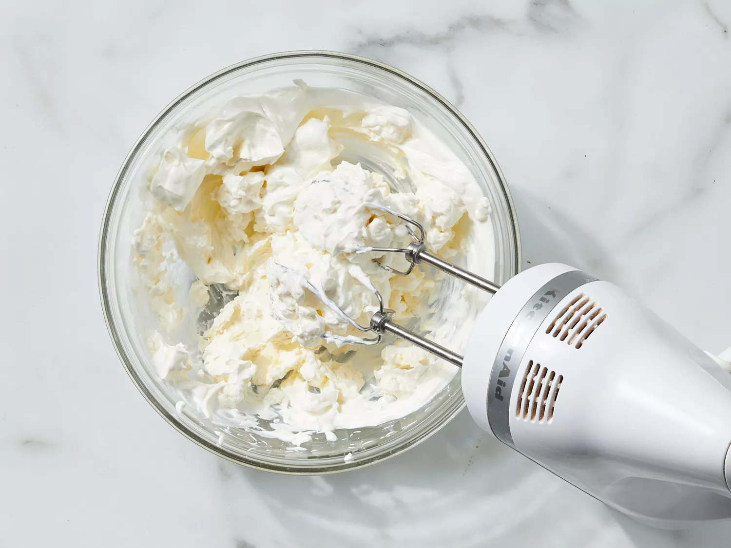 cream cheese and sour cream being blended