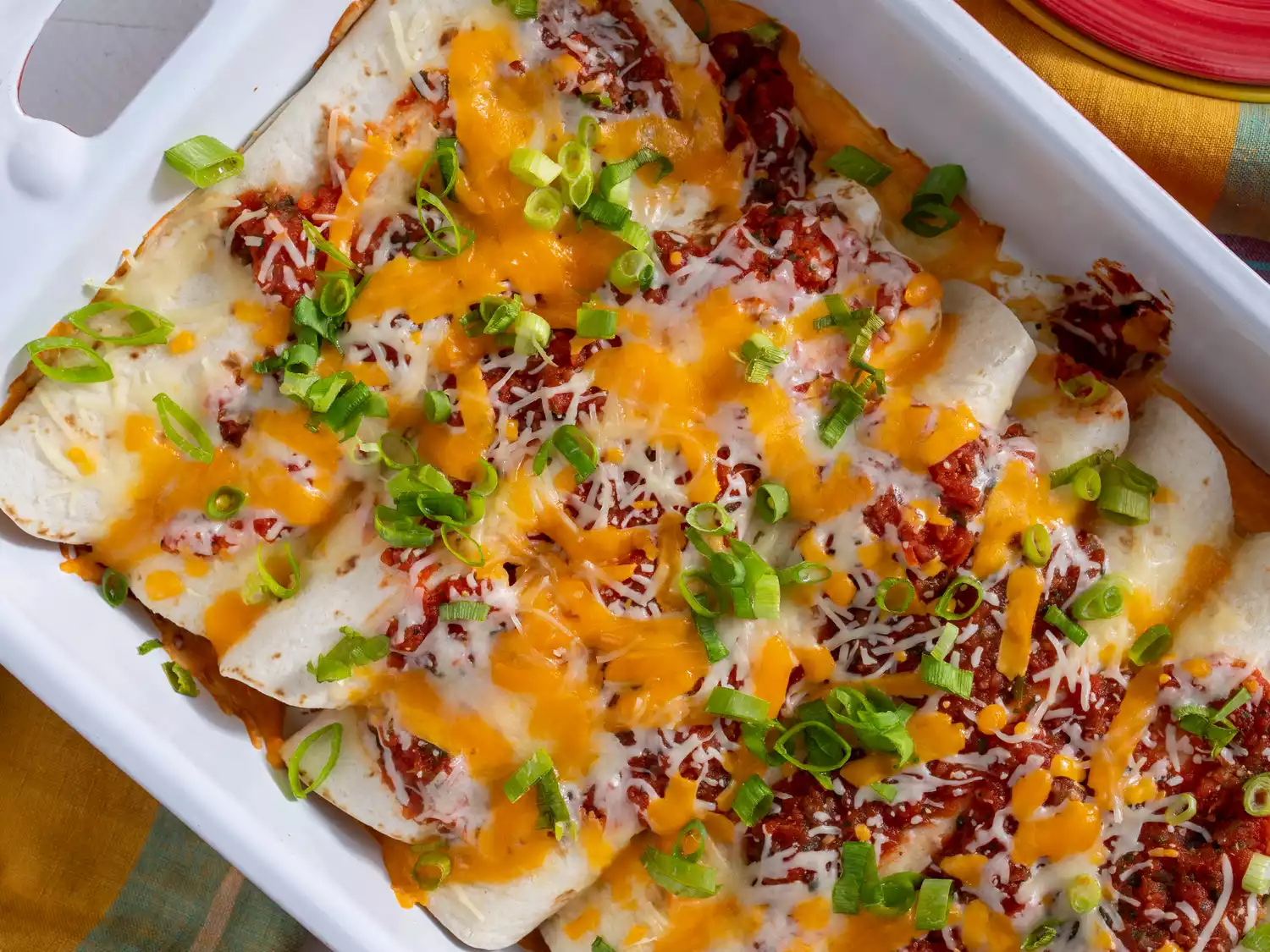 close up view of Cheese Enchiladas in a white baking dish