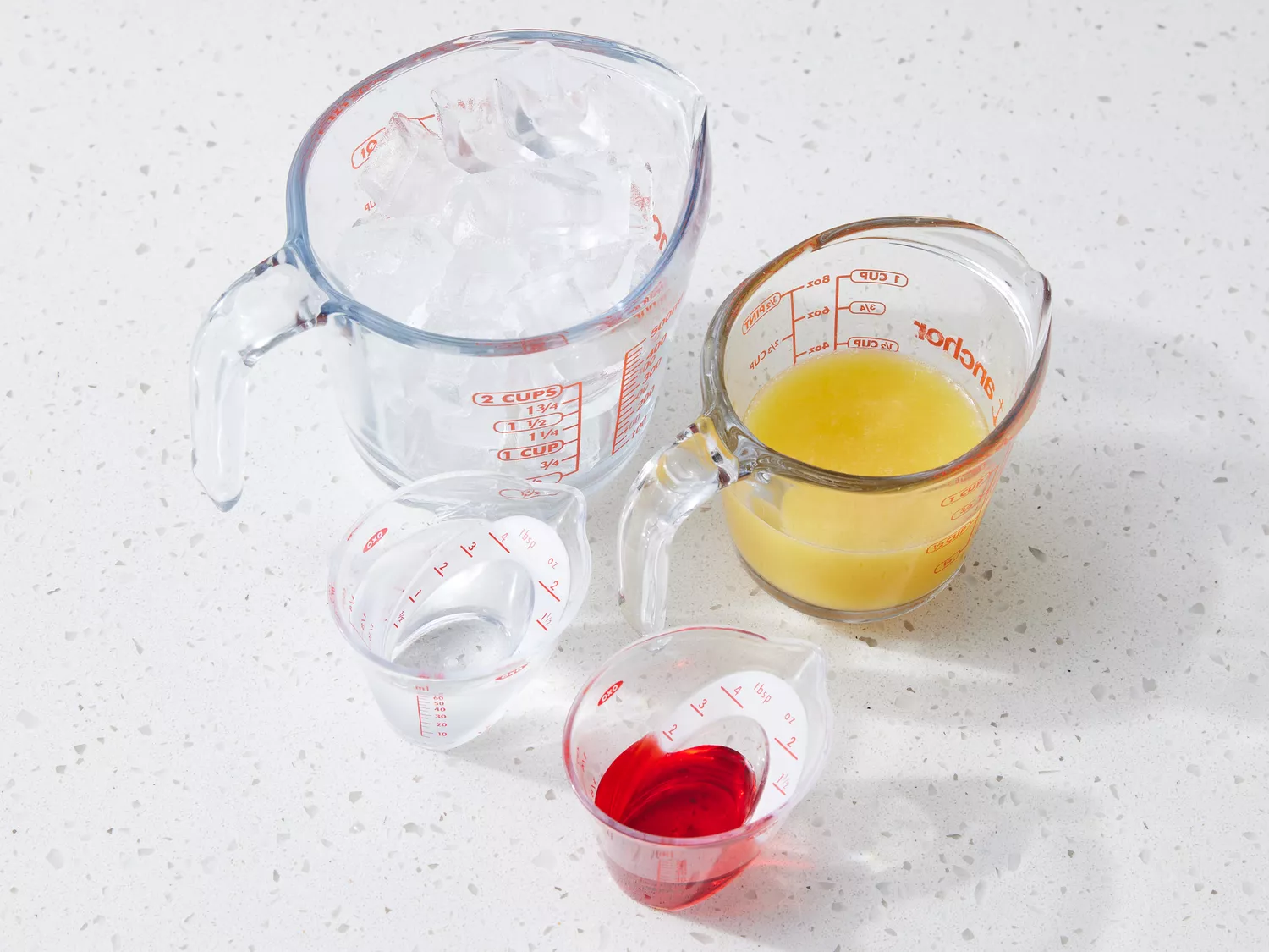Tequila Sunrise Cocktail ingredients on a white counter 