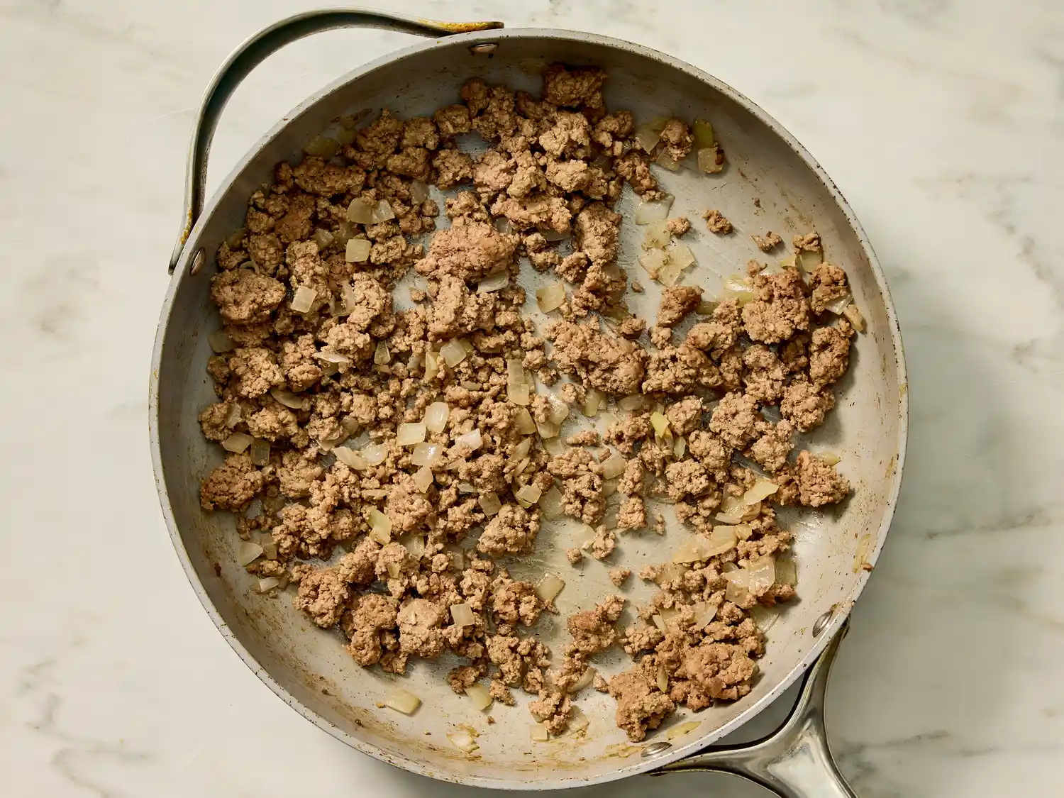 Cooked ground meat with onions in a skillet