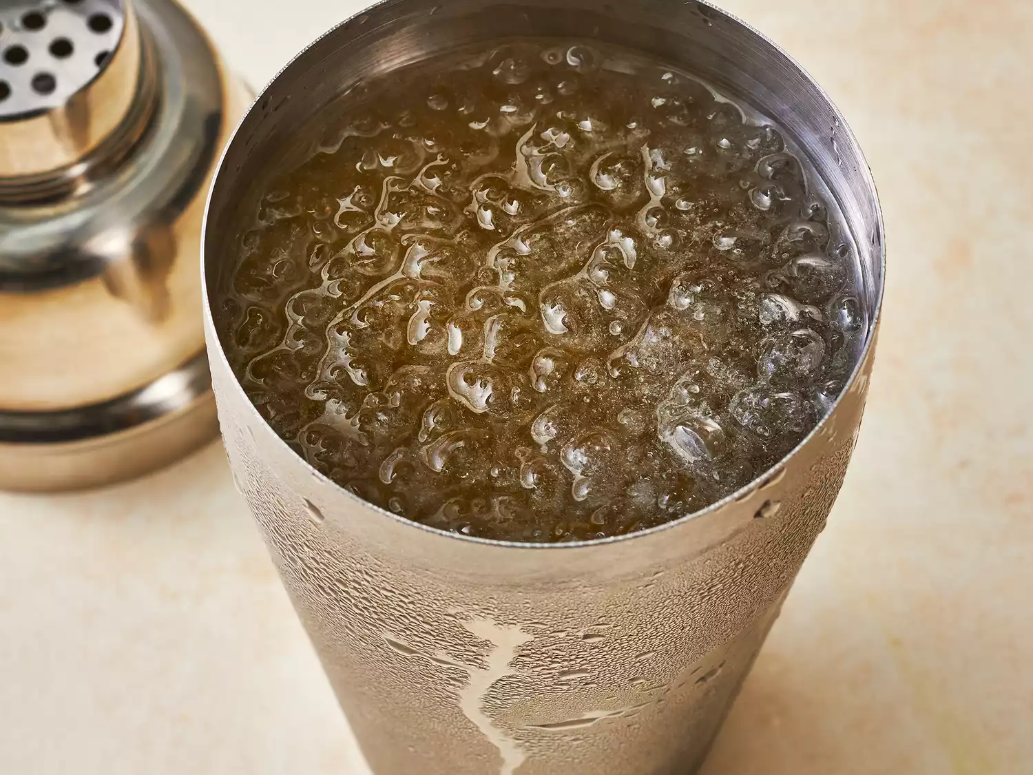 Cocktail shaker filled with vodka, rum, gin, tequila, triple sec and sour mix over ice.