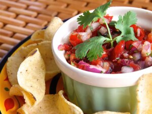 Salsa in a dipping bowl with tortilla chips surrounding it.