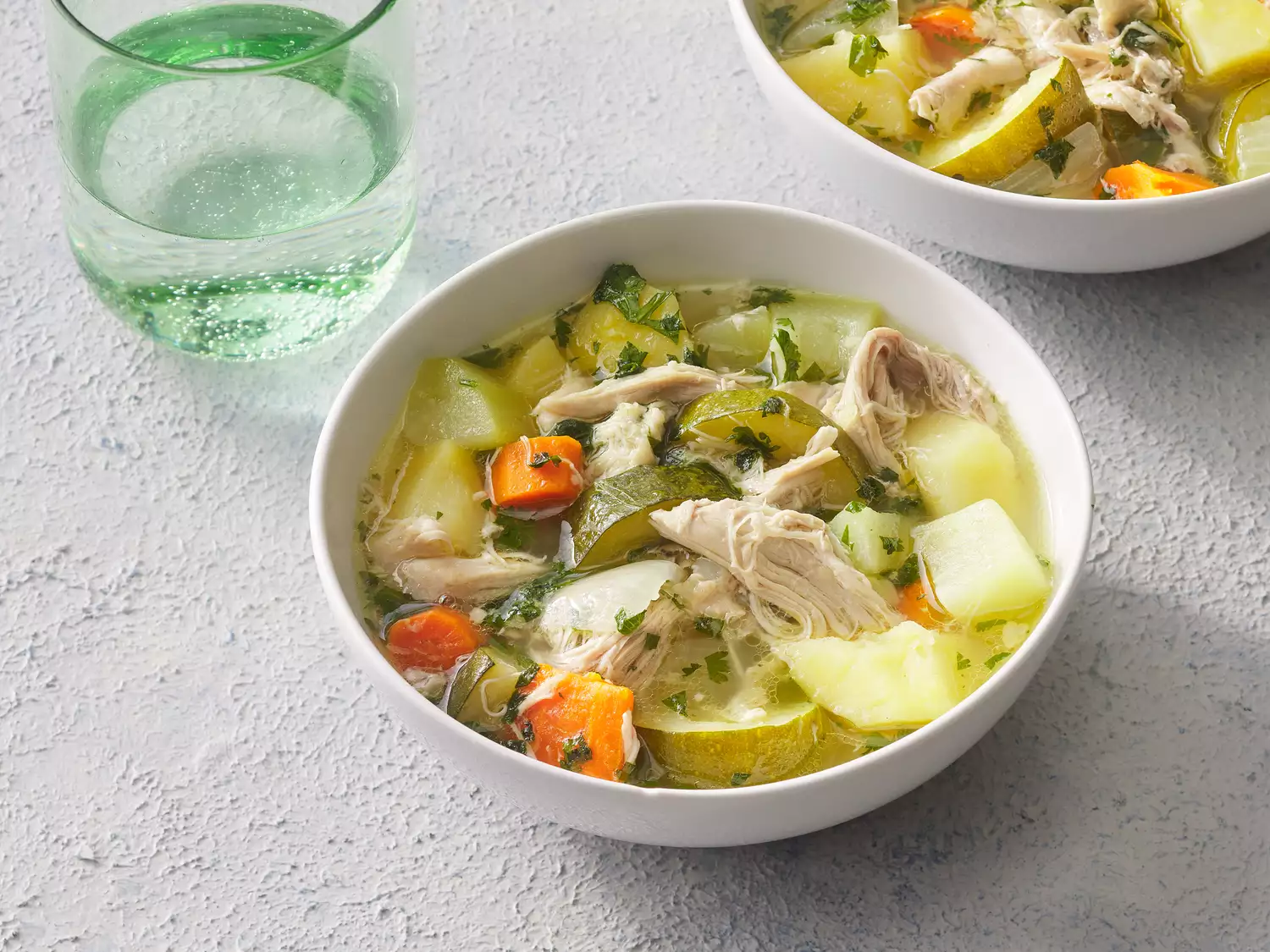 Caldo de Pollo with herbs in a white bowl