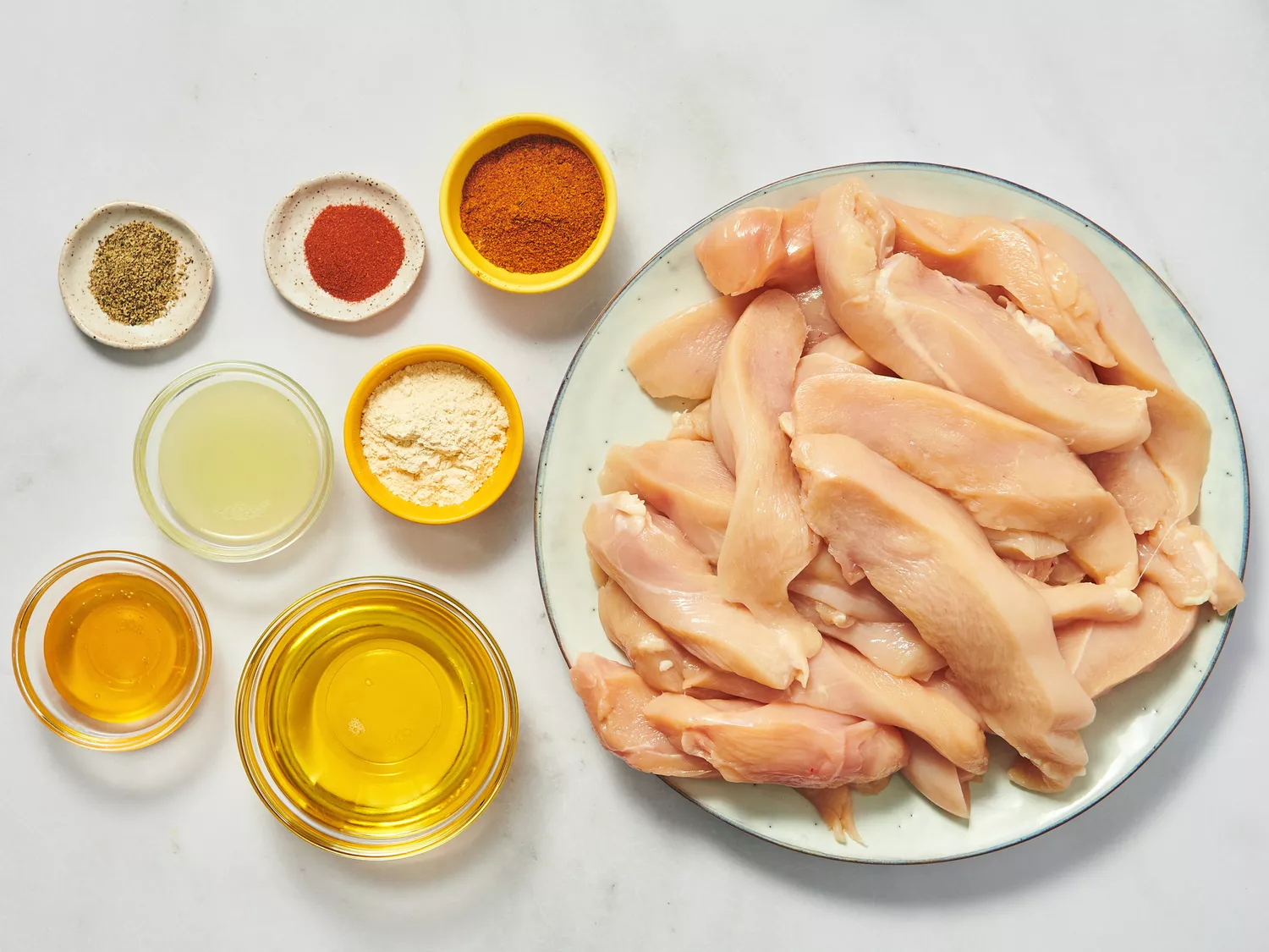 Ingredients for chicken fajita marinade including raw chicken and spices