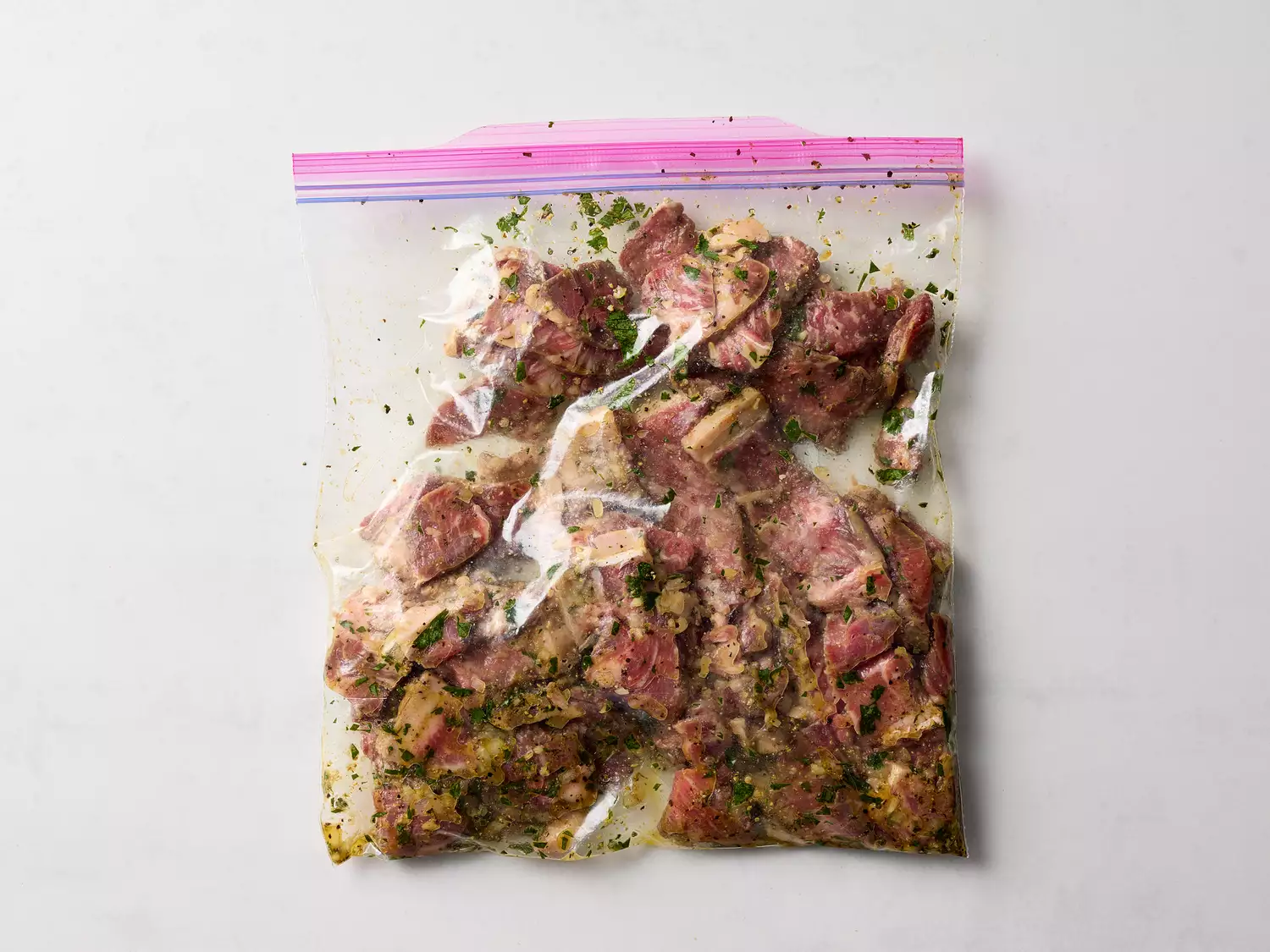 Marinated beef pieces in a sealed plastic bag