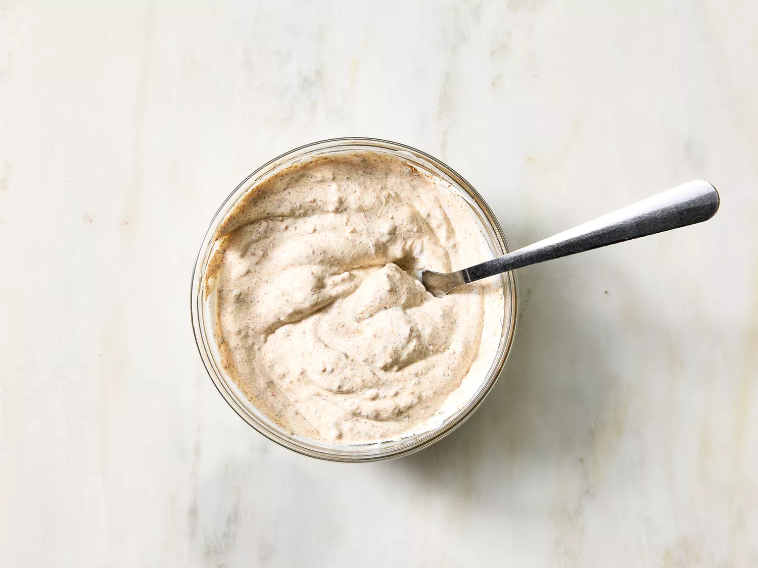Seasoned sour cream in a bowl for seven-layer dip.