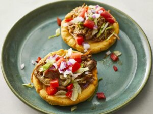 High angle looking at two mexican sopes on a plate