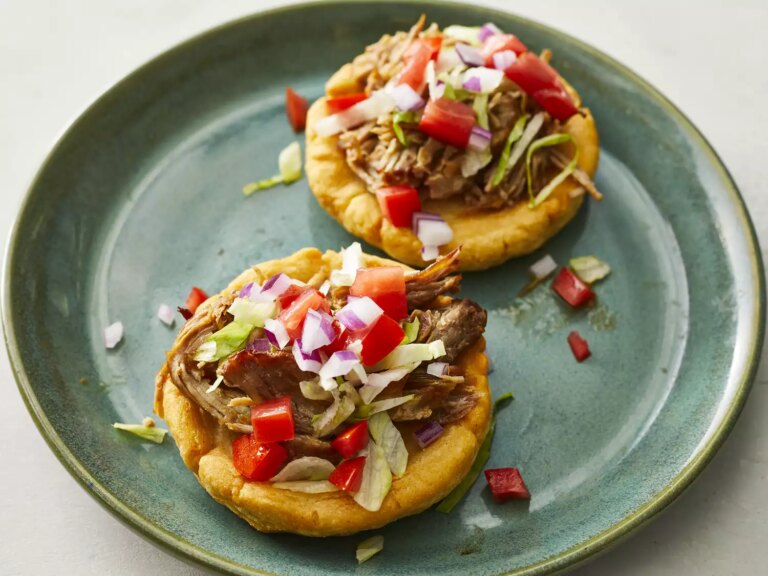 High angle looking at two mexican sopes on a plate