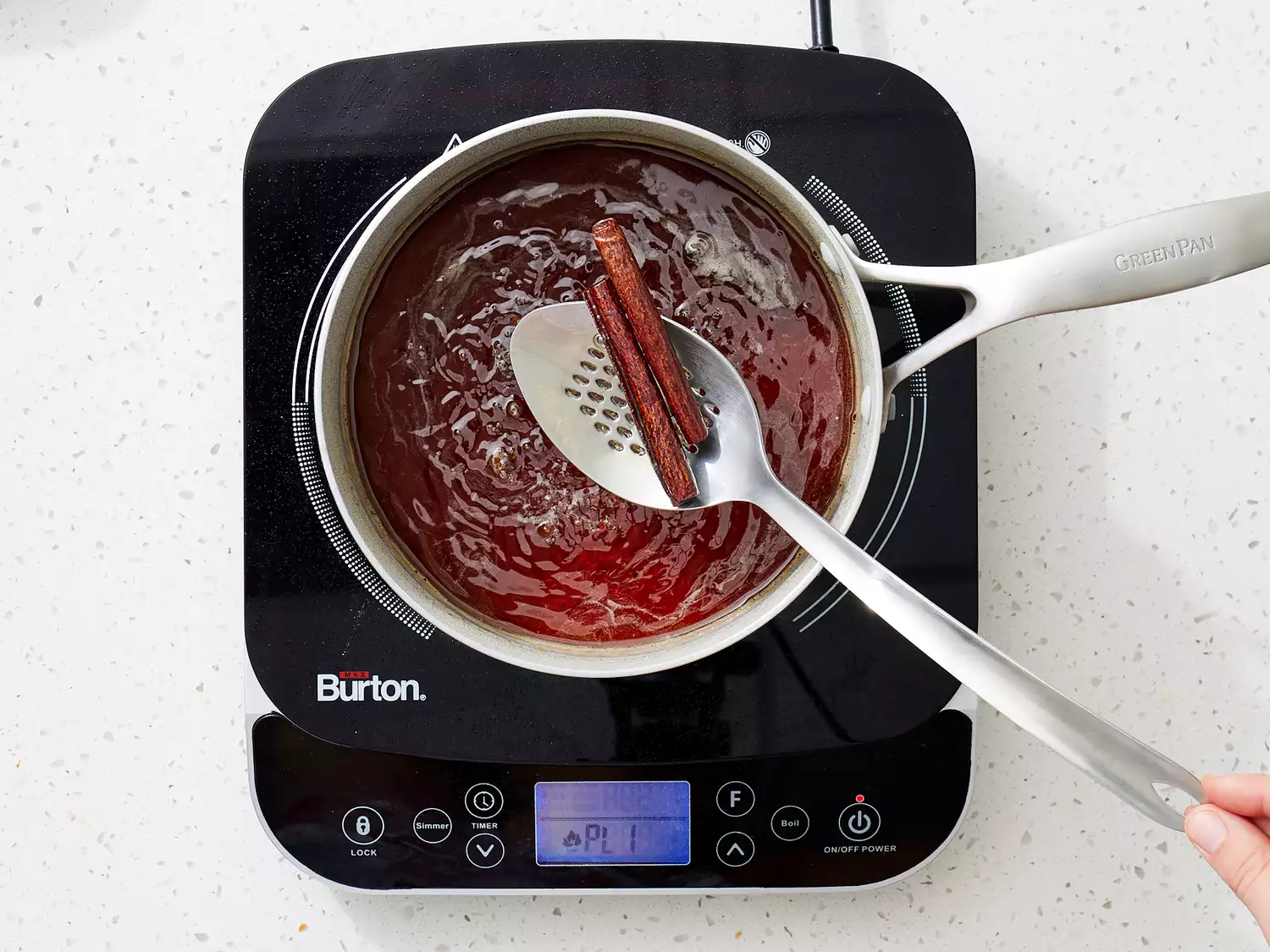 cinnamon sticks being removed from simple syrup.