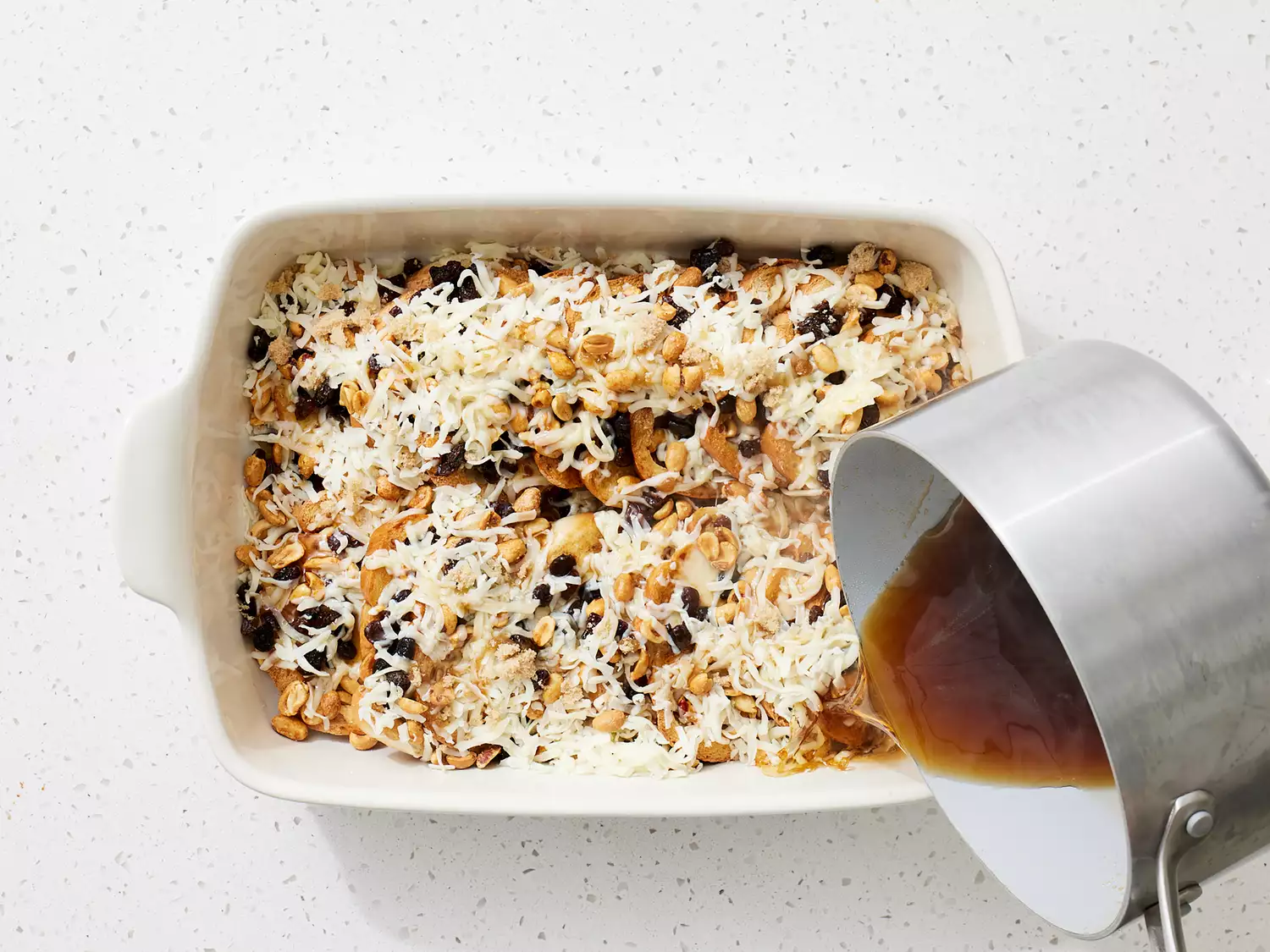 cinnamon, brown sugar syrup being poured over layered casserol