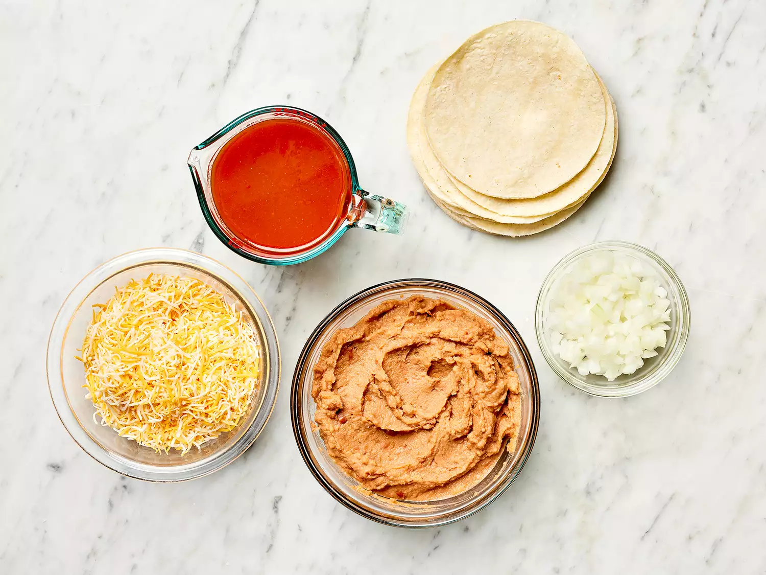 Refried Bean and Cheese Enchiladas ingredients on a marble counter 
