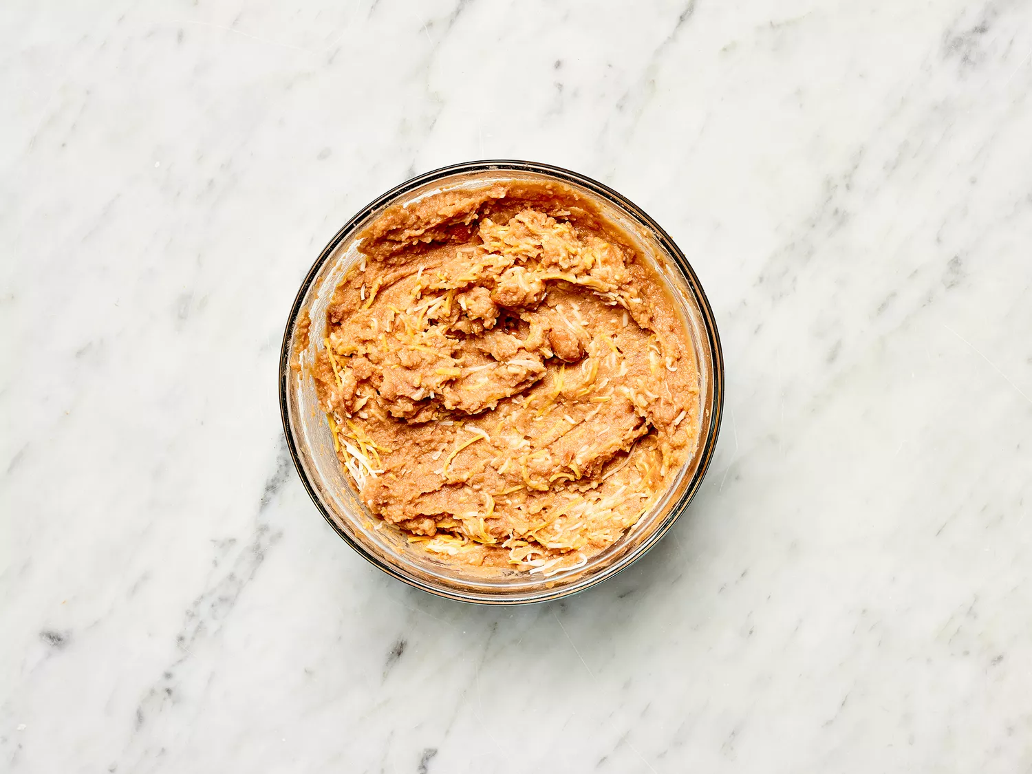Refried beans with cheese in a glass bowl 