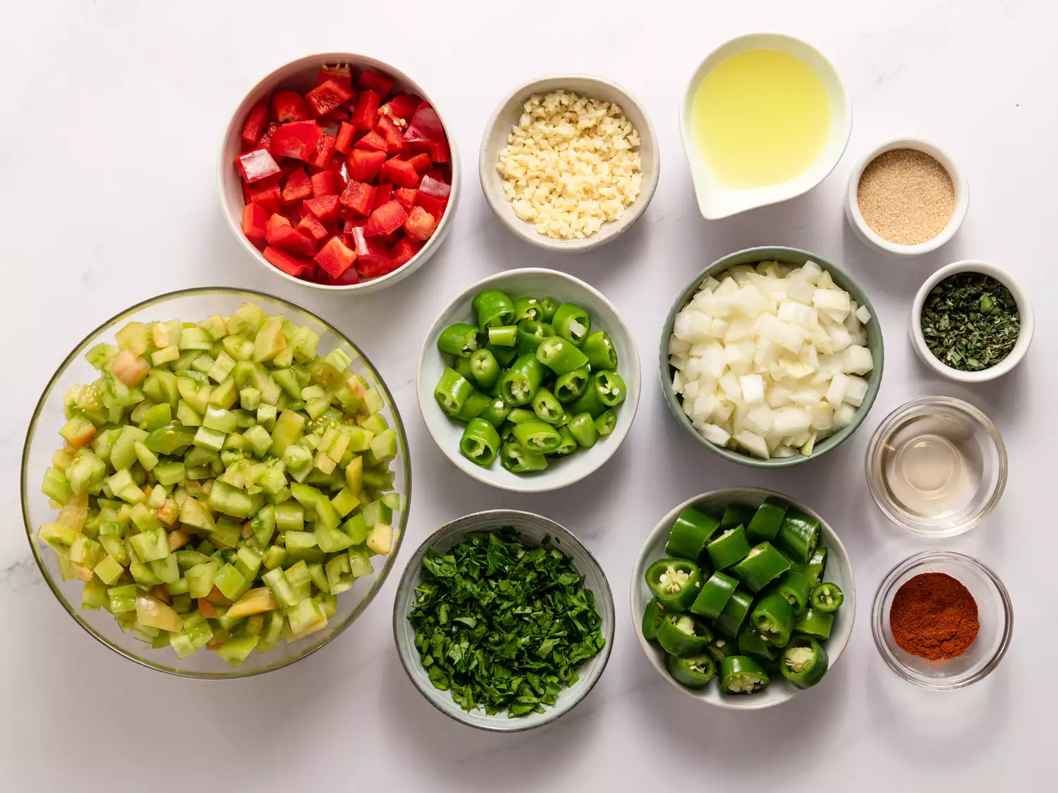 Spicy Green Tomato Salsa recipe ingredients on a marble counter 
