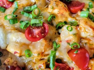 Close up of shrimp nachos with cherry tomatoes and scallions
