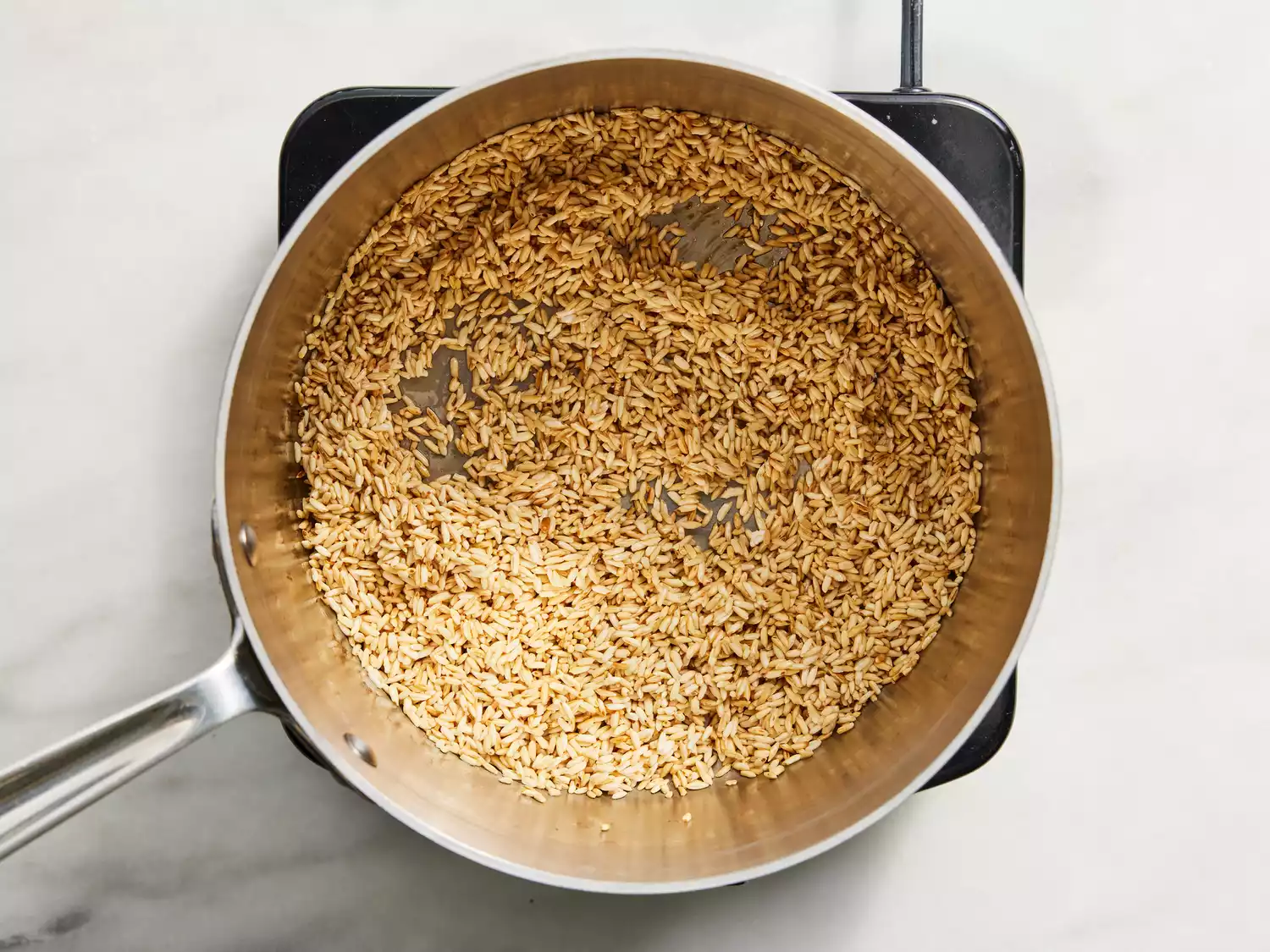 fry rice in a saucepan until golden-brown.