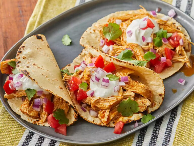 High angle, close up on a plate of three fiesta slow cooker shredded chicken tacos