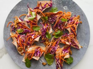 Close up on a bunch of chicken wonton tacos with red cabbage and cilantro