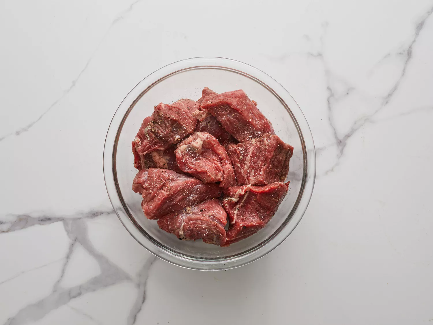 an overhead shot of seasoned beek chunks in a bowl