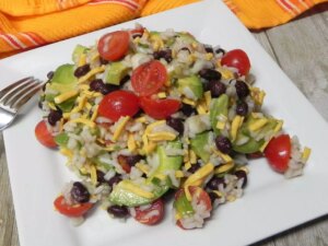 Rice salad with avocado, black beans, cheese, and cherry tomatoes