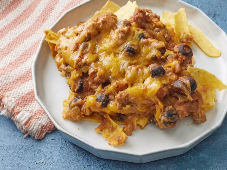 High angle looking at a plate of taco bake casserole with cheese and black olives on a plate