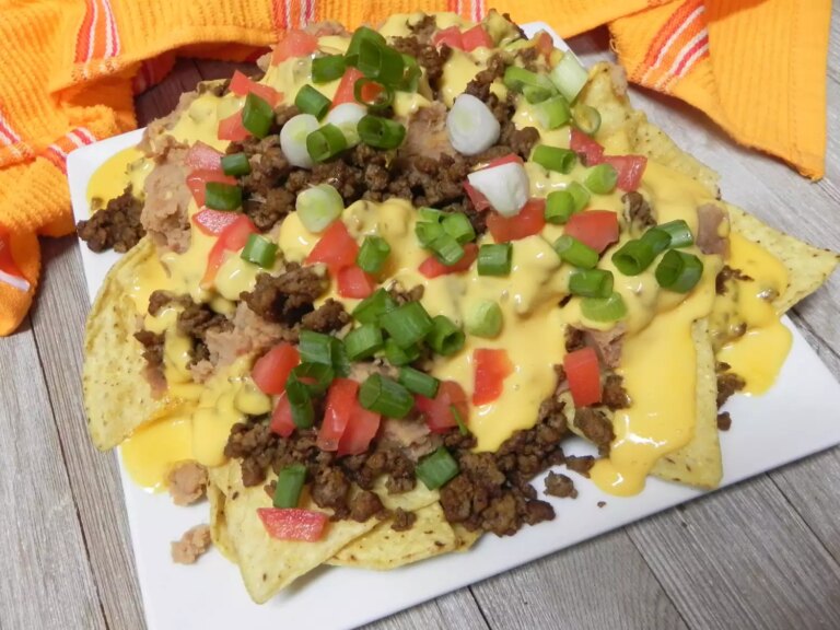 Ground beef taco nachos topped with cheese, tomatoes and green onions