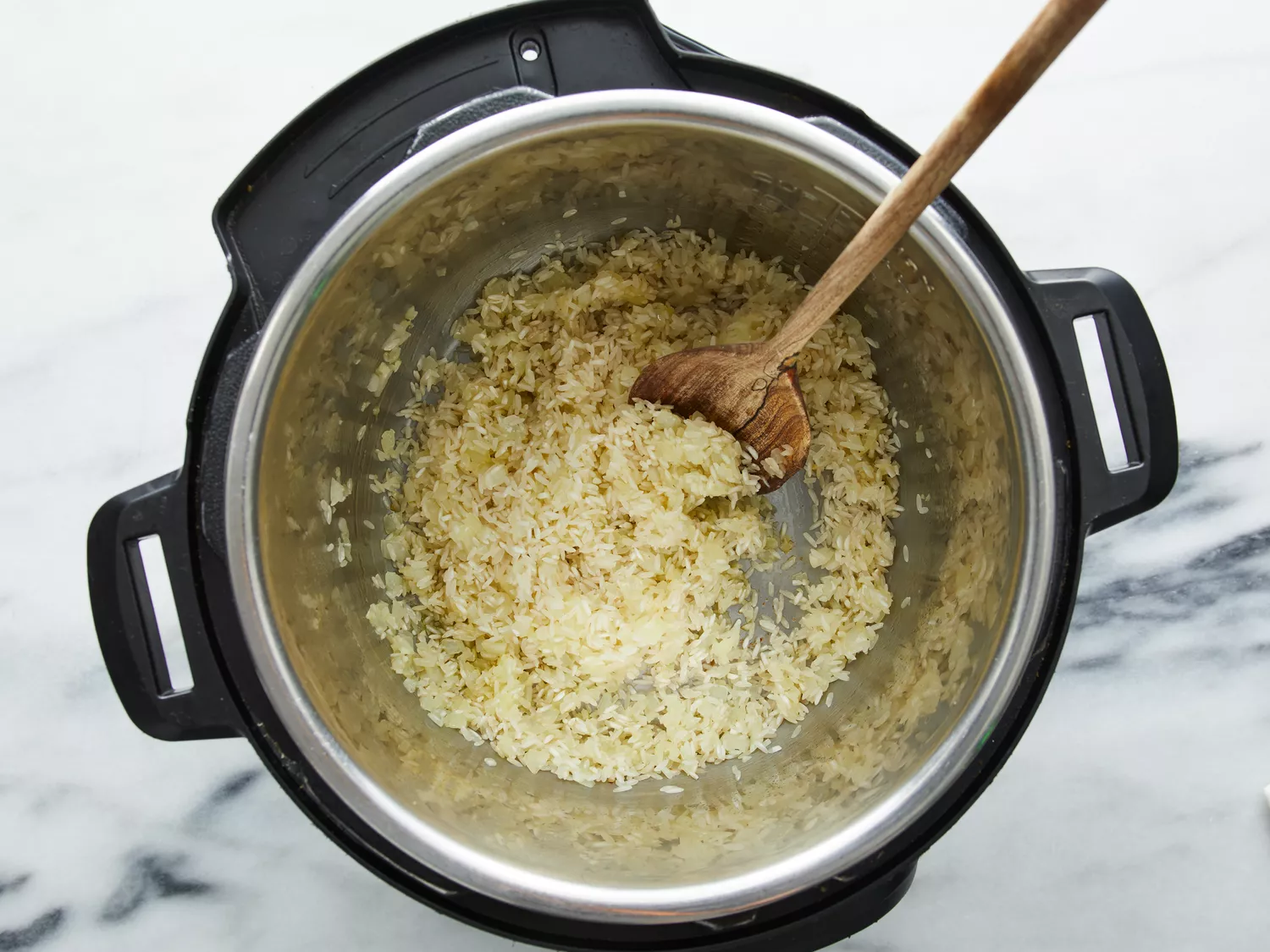 Rice added to pressure cooker, cooking until browned.