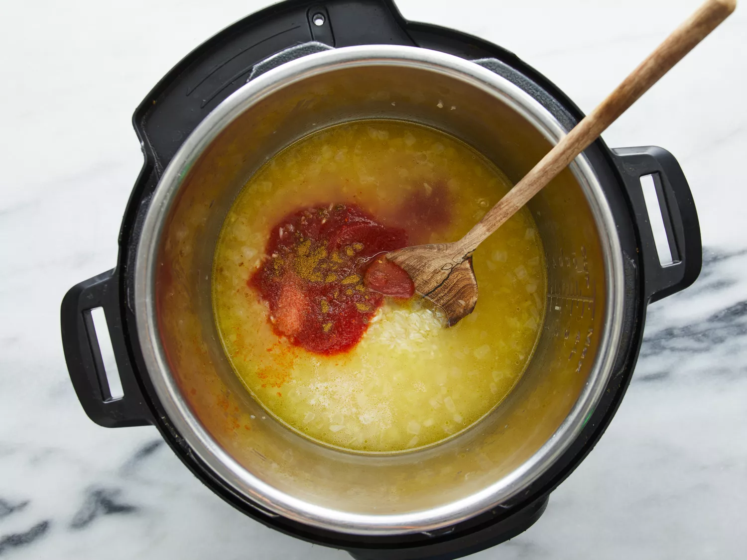Tomato sauce, salt, cumin, and cayenne pepper added to pressure cooker.