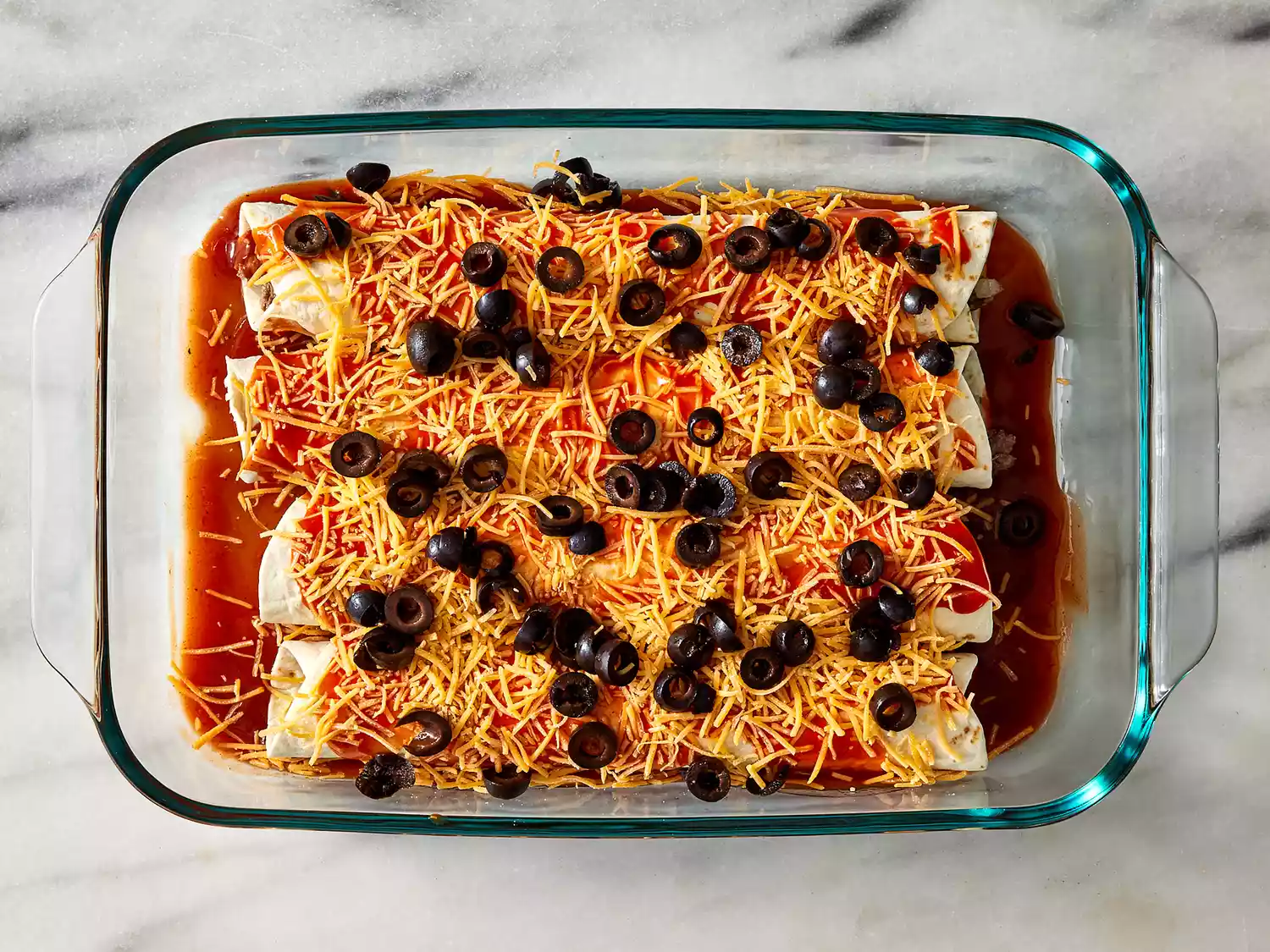 Remaining sauce poured over, then topped with cheese and olives.