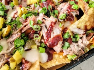 Loaded pulled pork nachos on baking sheet