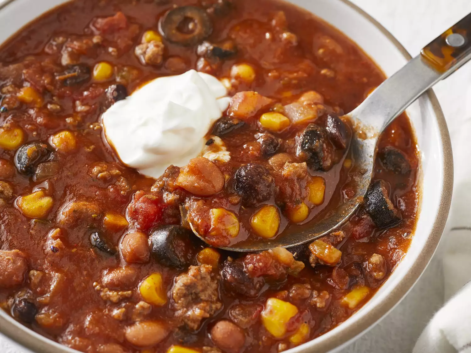 High angle looking at a bowl of ranch taco soup, with a spoonful coming out