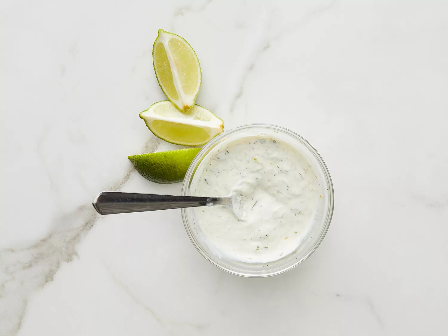 Overhead of a mixed crema with three lime wedges off to the side. 