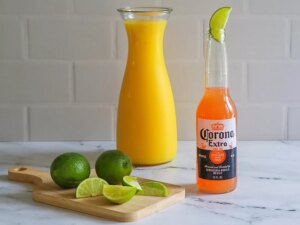 Corona sunrise with orange juice and lime in the background