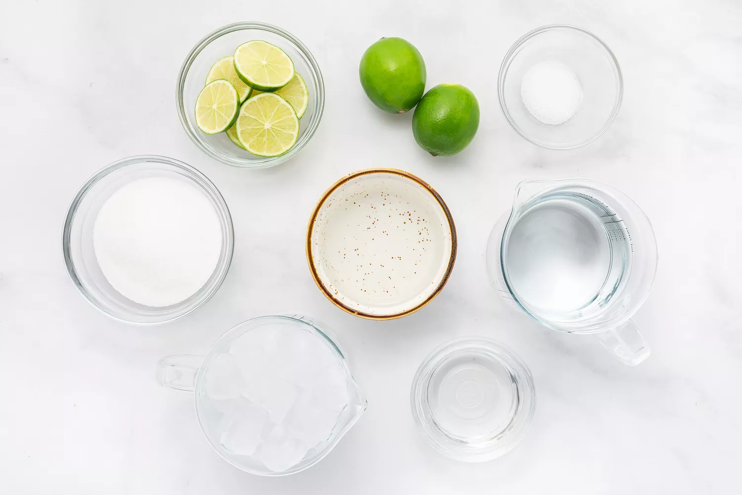 Various bowls filled with ingredients to make whole lime margarita.
