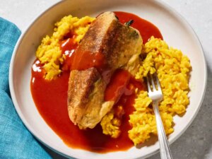 Looking down at a plate of chiles rellenos with a side of spanish rice