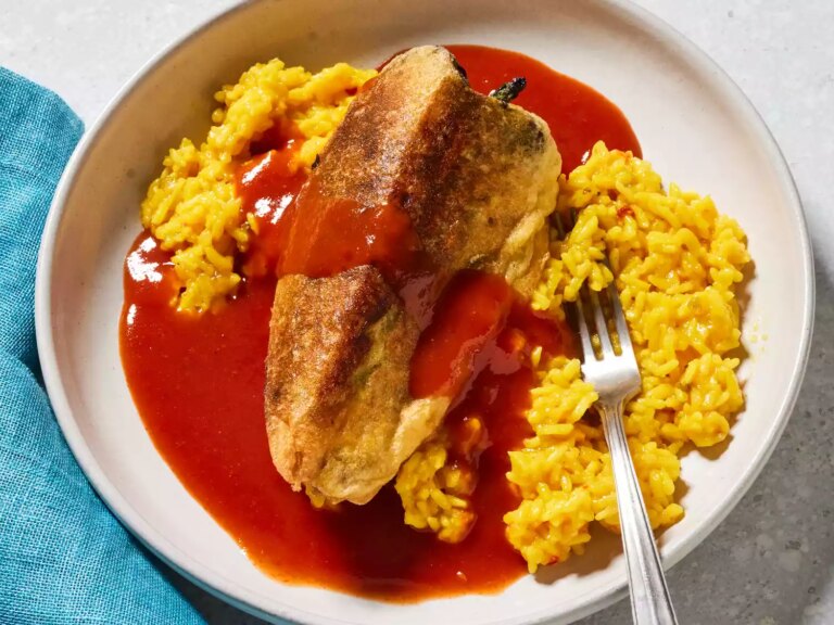 Looking down at a plate of chiles rellenos with a side of spanish rice