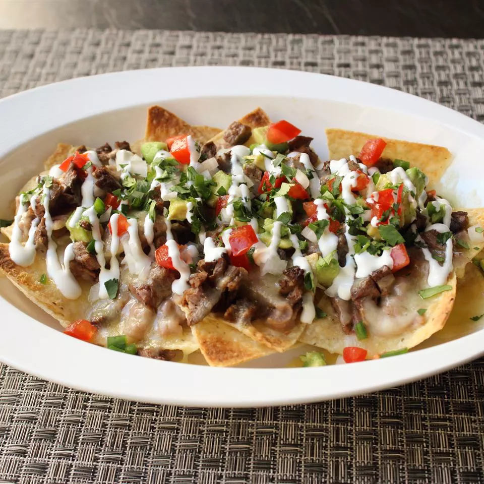close up view of Super Deluxe Steak Nachos on a platter