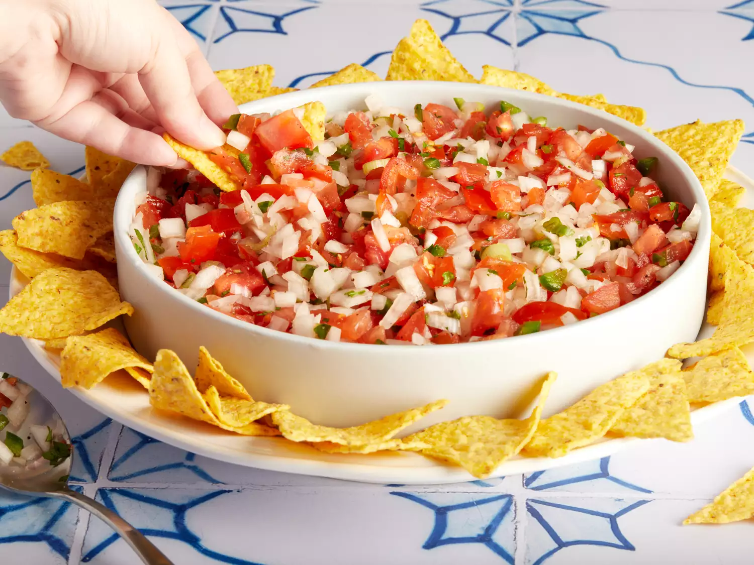 A bowl of Pico de Gallo served with tortilla chips.