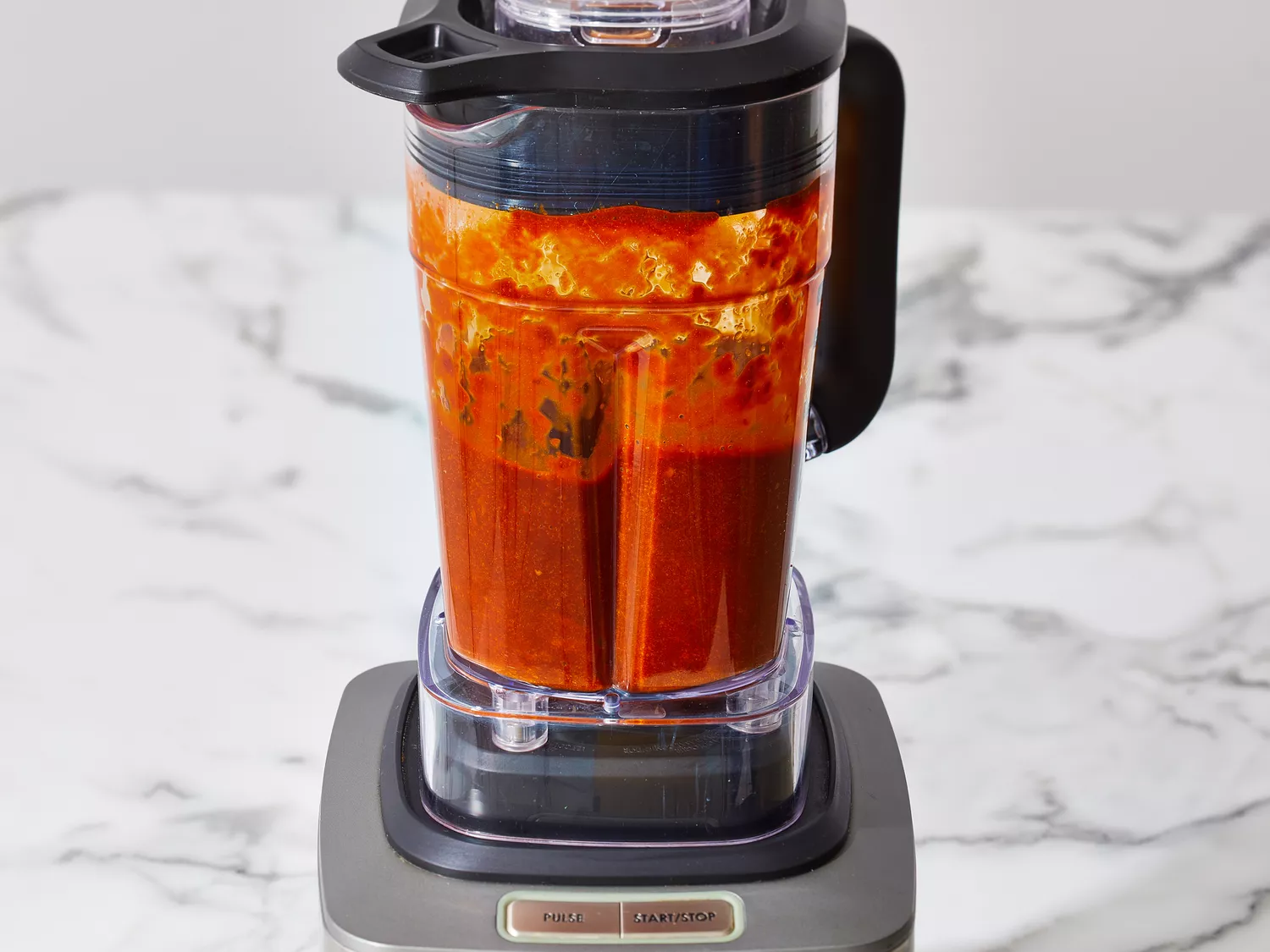 Chiles and liquid placed in a blender, puréeing until smooth.