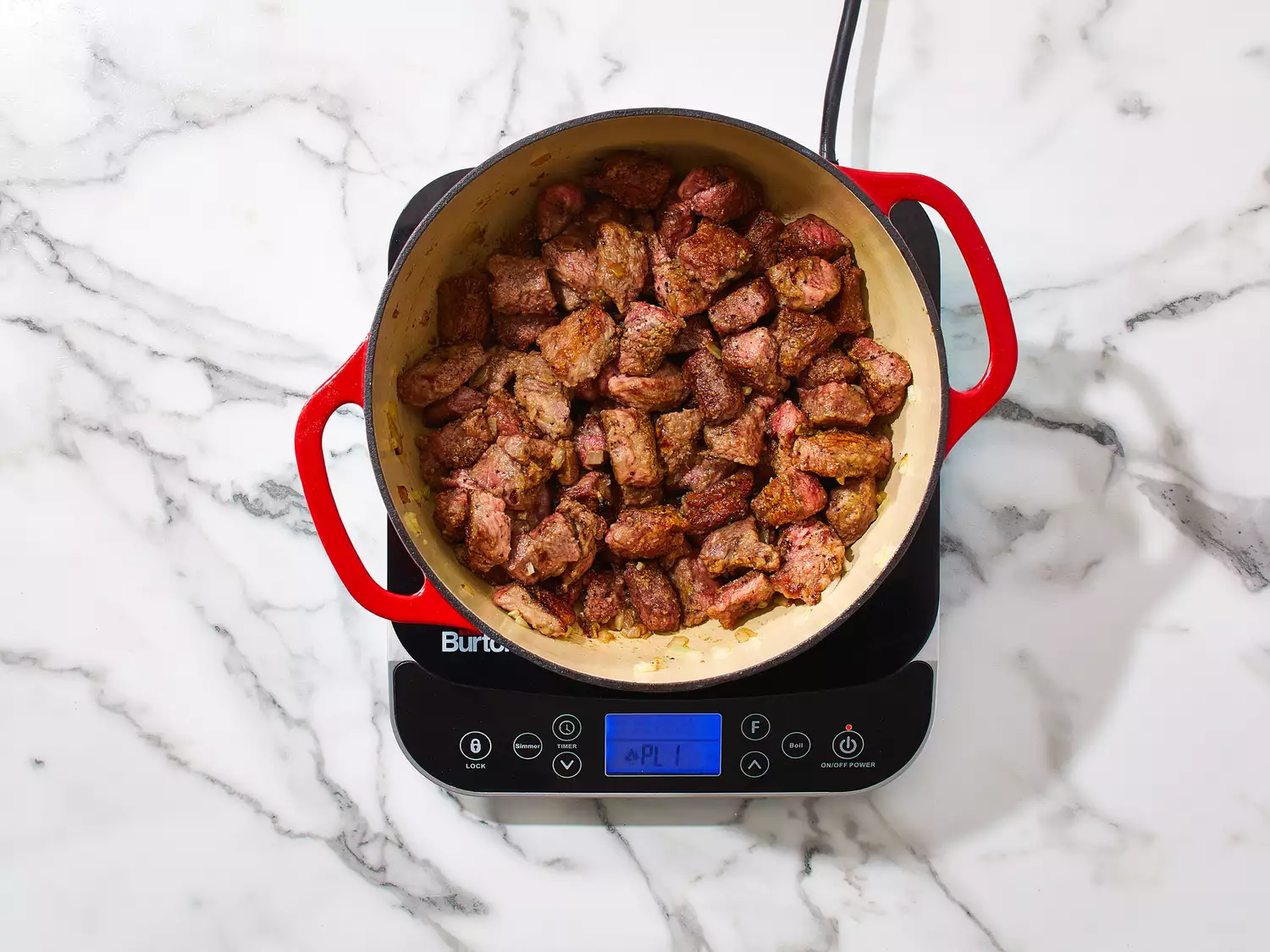 Beef added to pot, cooking until browned.