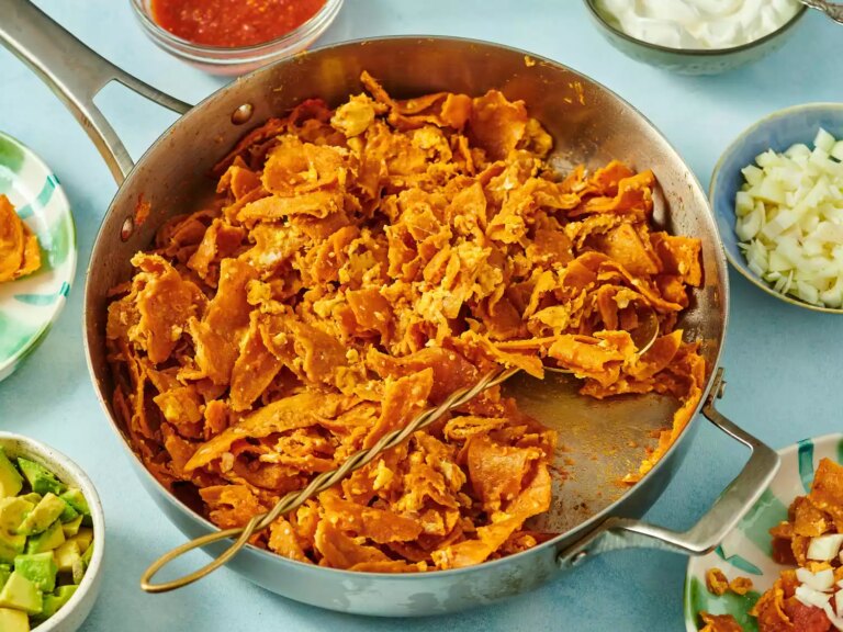 A pan of chilaquiles, surrounded by various toppings