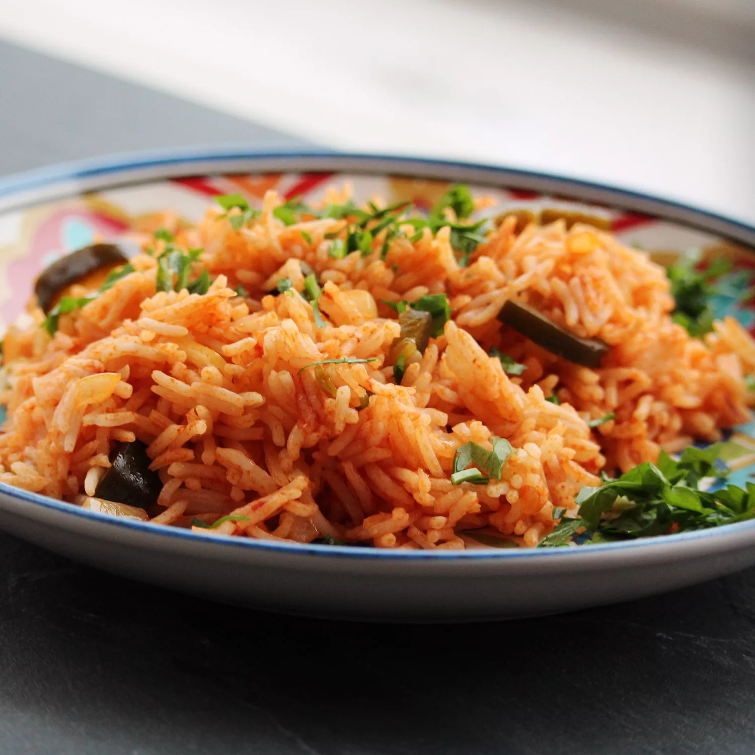 close up view of Mexican rice garnished with herbs in a bowl