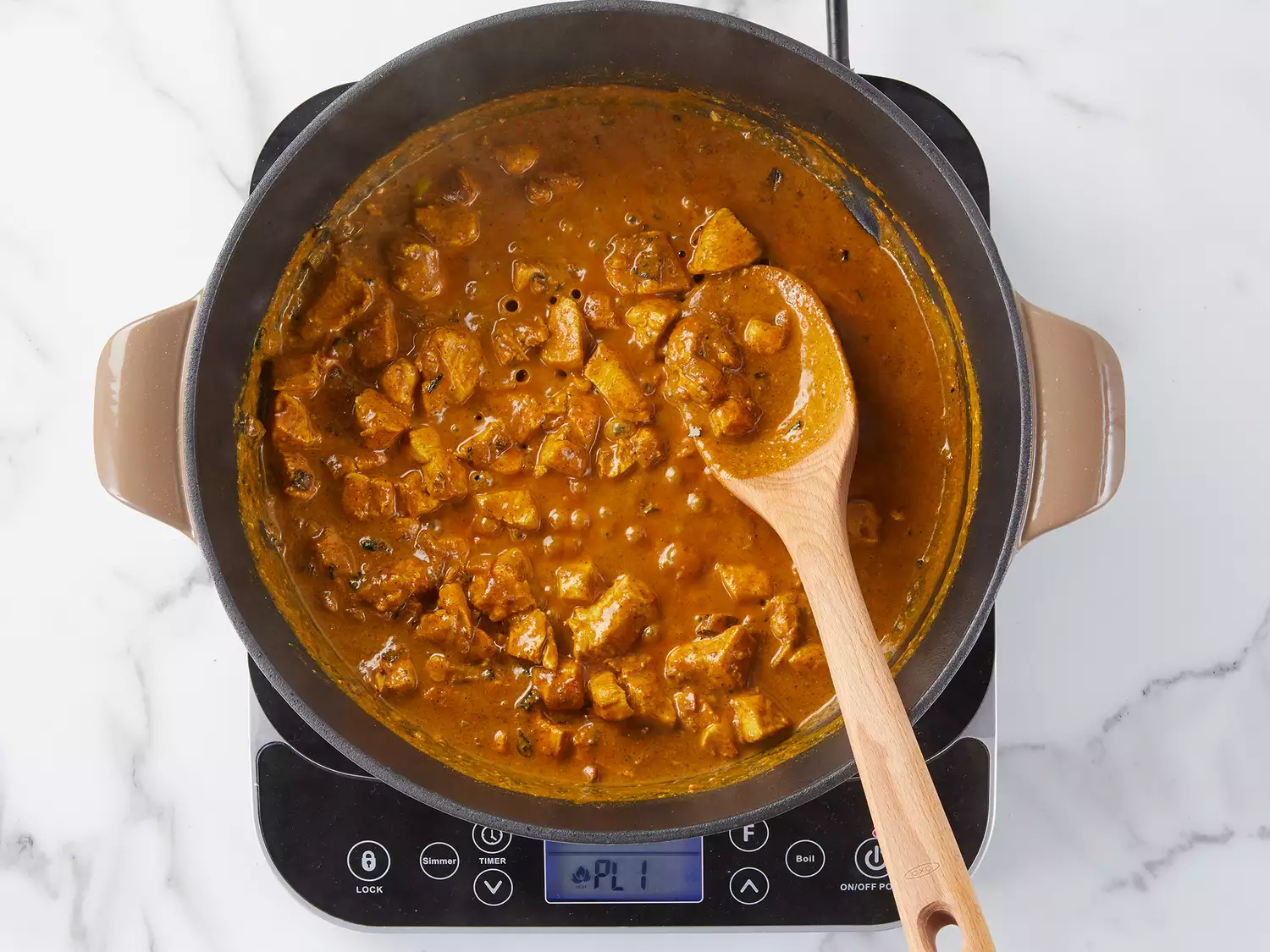 Chicken curry simmering in a skillet. 