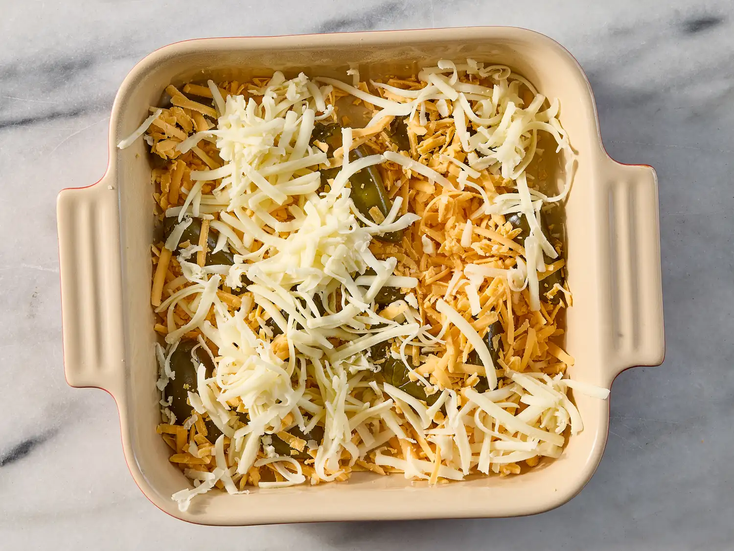 Cheesecovered casserole with peppers in a square baking dish