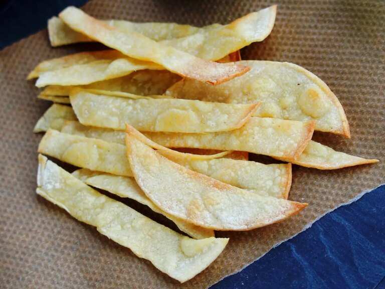 Close up view of baked corn tortilla strips on a baking sheet