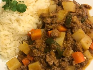 Close up view of authentic mexican picadillo served with white rice garnished with fresh herbs