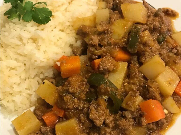 Close up view of authentic mexican picadillo served with white rice garnished with fresh herbs